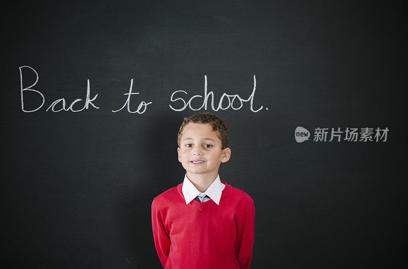 6岁的小男孩站在黑板前