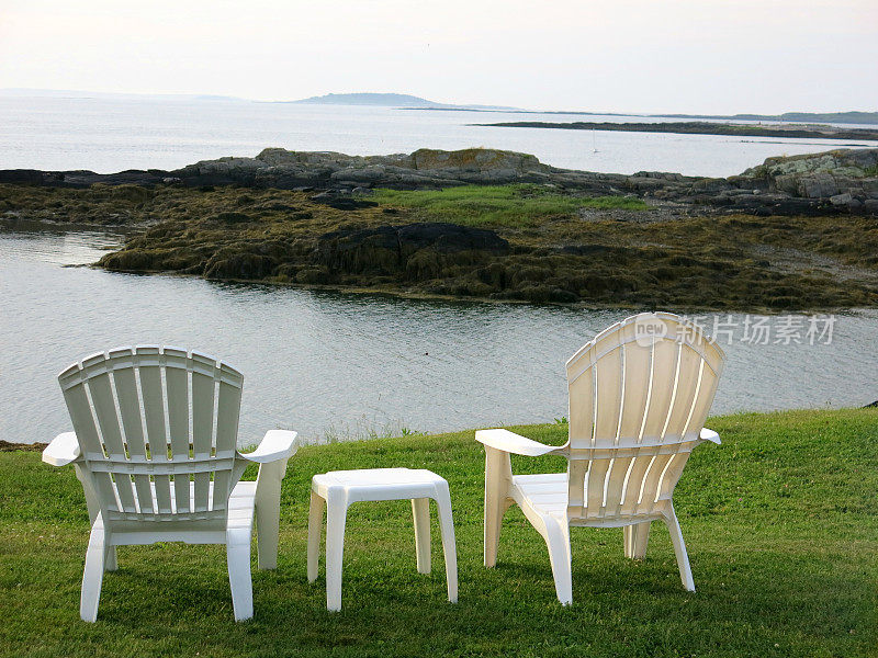 缅因州海滨的两张白色空阿迪朗达克度假椅