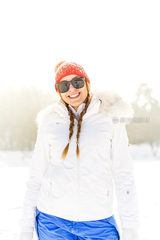 在雪地里戴着太阳镜和帽子的女人