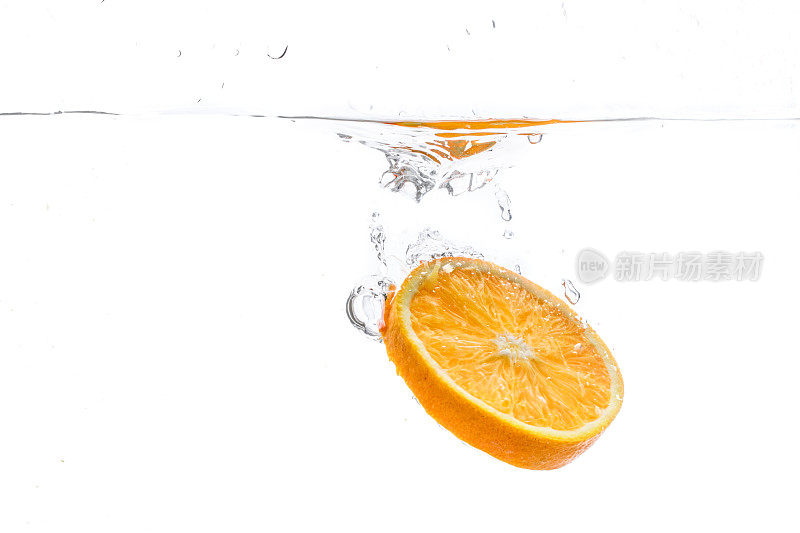 橘子片在水里飞溅。白色背景