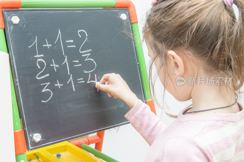 棋盘上的女孩在解数学题。训练孩子。