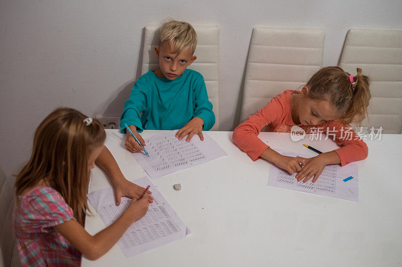 不开心的男孩和姐妹们一起写作业