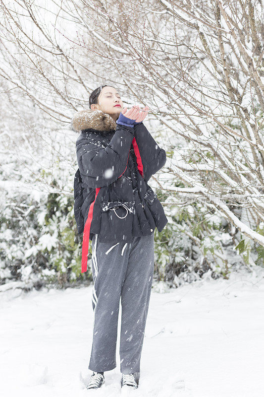 一个美丽的亚洲女人站在雪地里的肖像