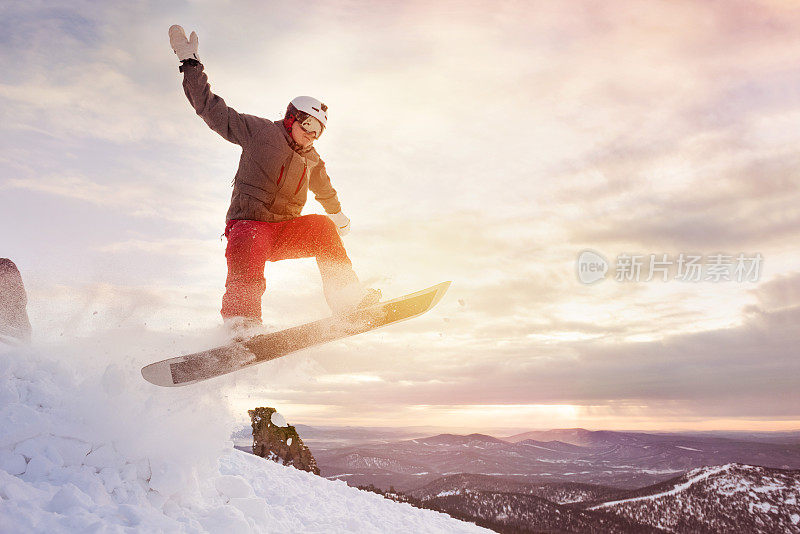 滑雪板在夕阳下跳跃