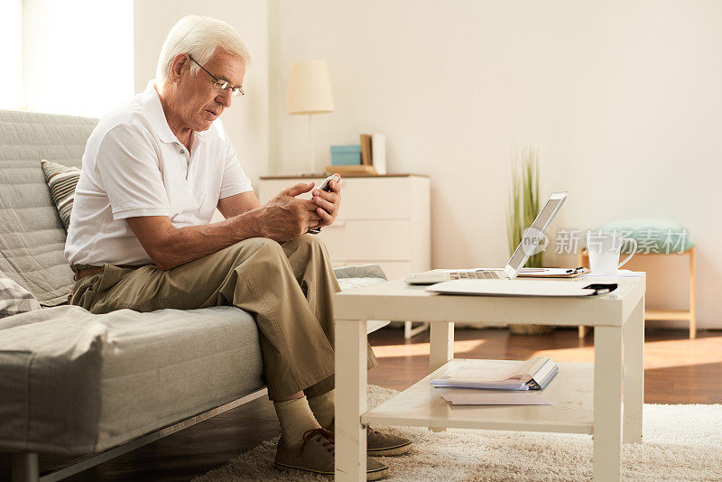 在家里使用智能手机的老年人