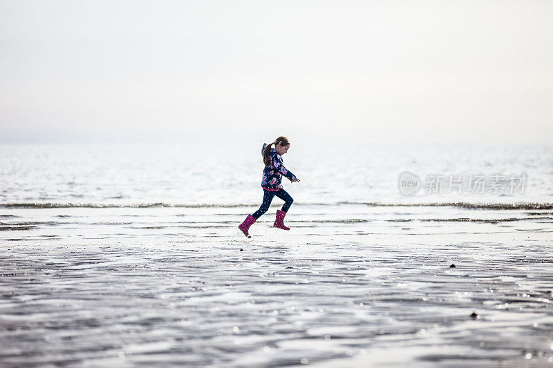 落潮时，小女孩在海滩上奔跑