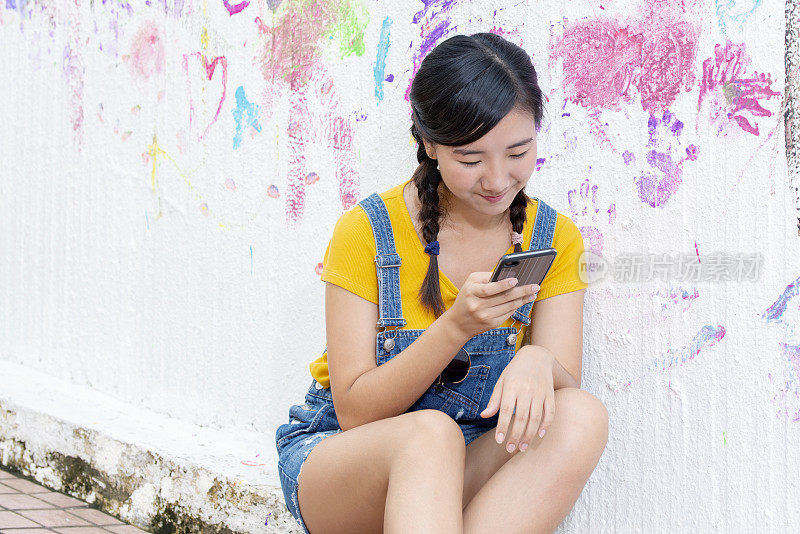 亚洲少女在街上使用智能手机