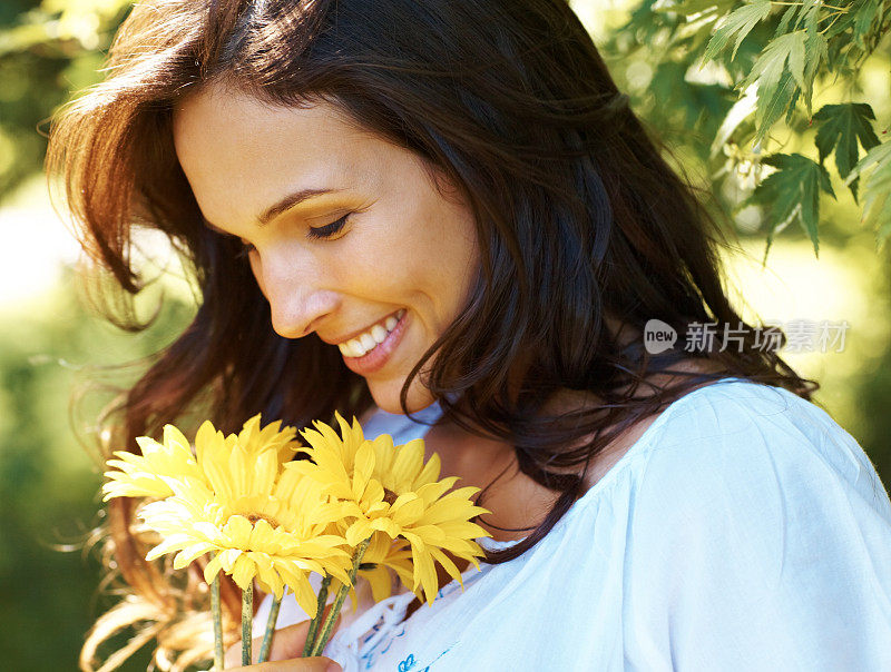 公园里一个漂亮的年轻女子，带着黄花