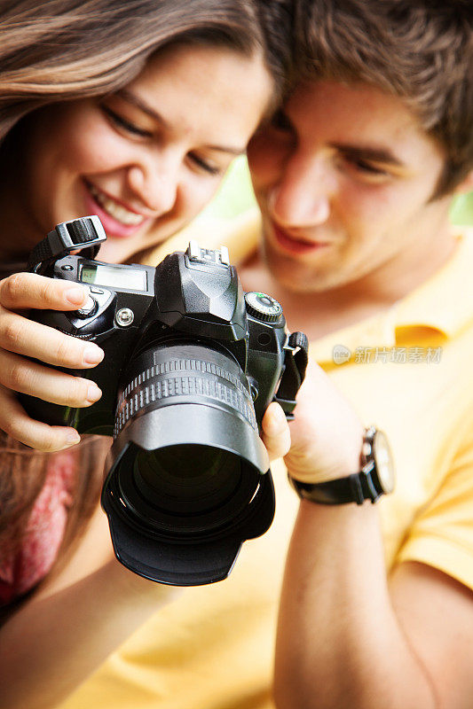 一对年轻夫妇看着相机拍下的照片
