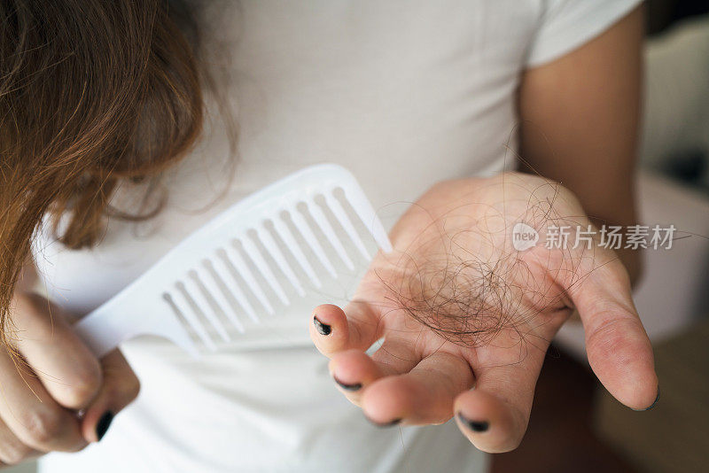 手里拿着梳子的女人正在掉头发