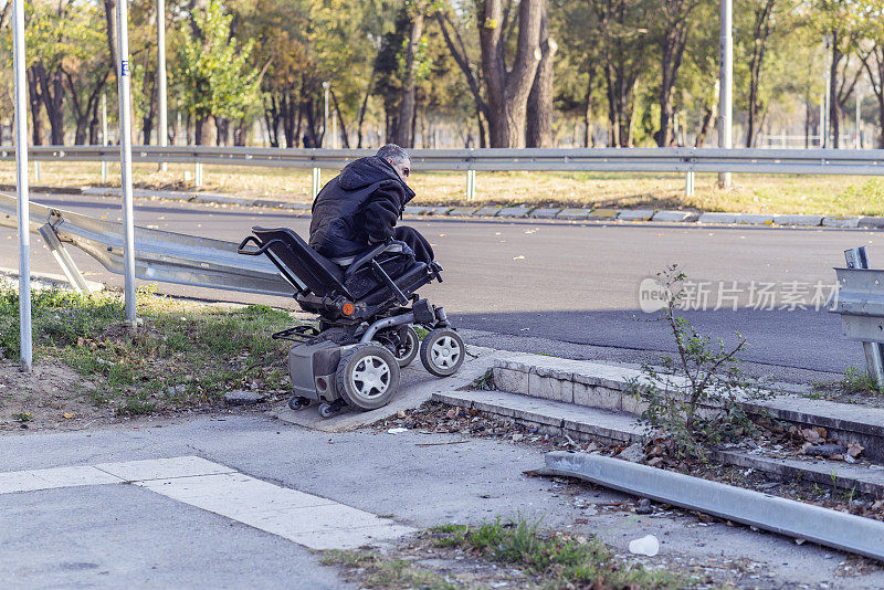 坐在电椅上的残疾人正在避开路上的障碍物