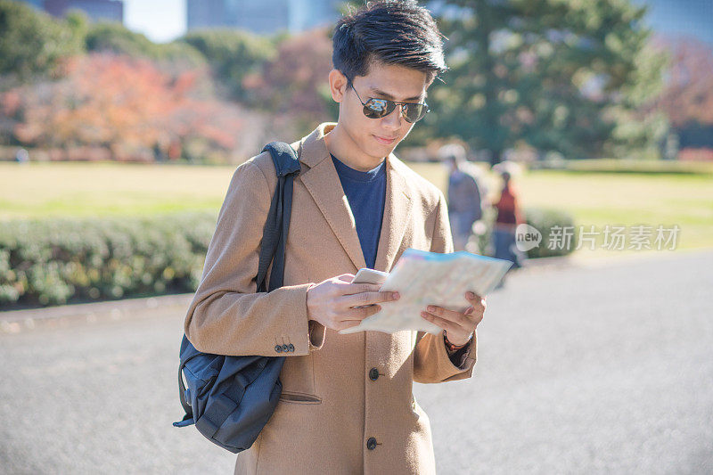 年轻的亚洲人日本人寻找旅游地点使用手机和花时间在亚洲旅行