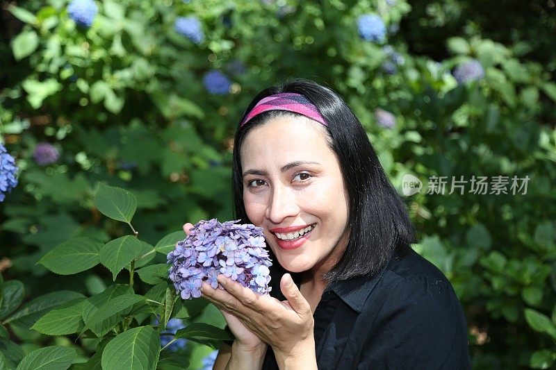 女人在闻绣球花。