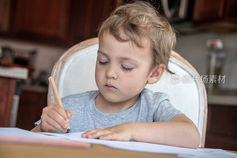 一个三岁的男孩正在做作业