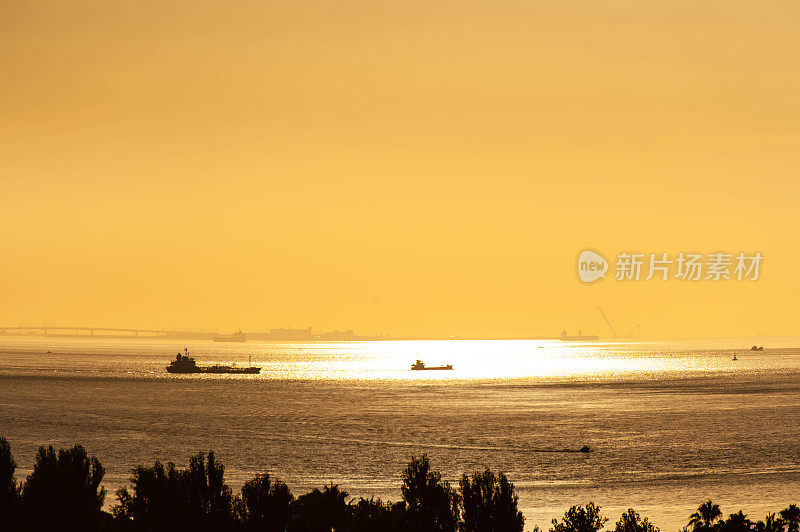 一艘船在早晨的阳光下航行在波光粼粼的海面上
