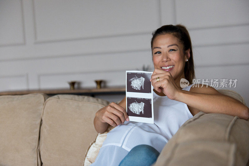 中年孕妇自豪地展示超声波照片