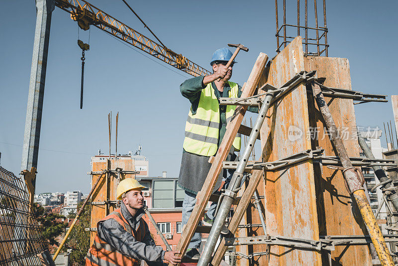 建筑工人正在建筑工地上和铁锤一起工作