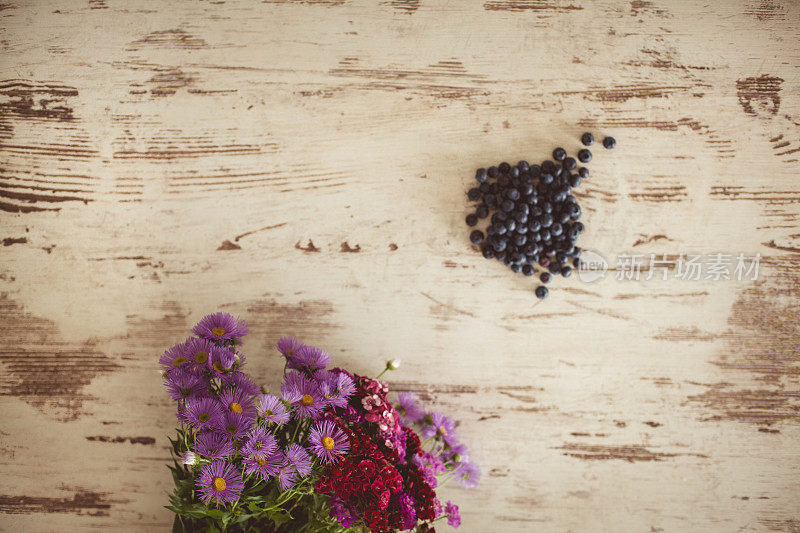 木质背景上的花和蓝莓