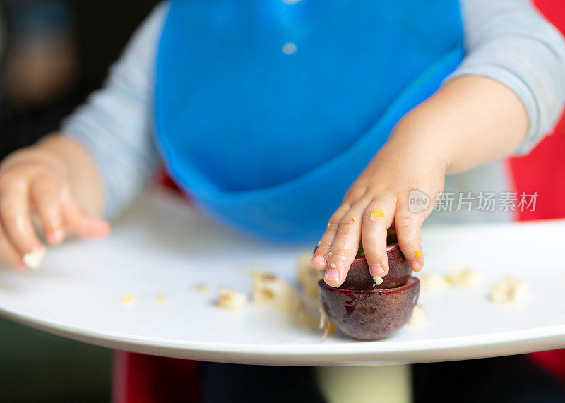 17个月大的男孩好奇地调查和探索他的食物