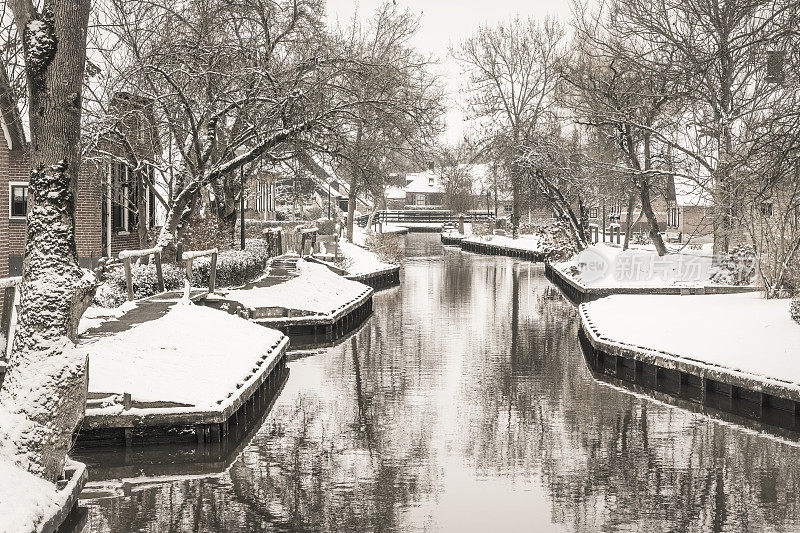 在一个寒冷但美丽而平静的冬天，Giethoorn村附近的Dwarsgracht有积雪的运河