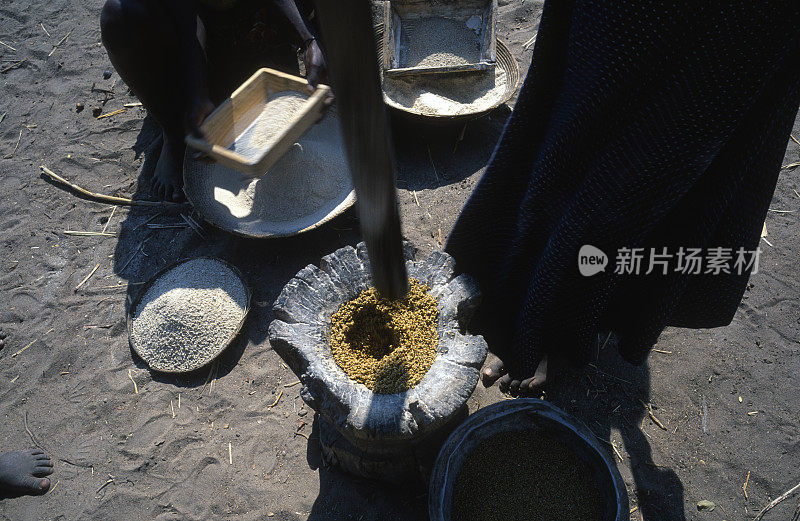 一个土生土长的安哥拉妇女在磨谷物做食物