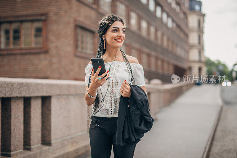 一名年轻女子在市中心的街道上使用智能手机