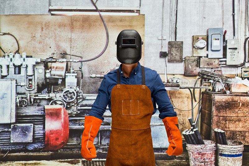 白种年轻男性工匠戴着工作头盔在工厂修理