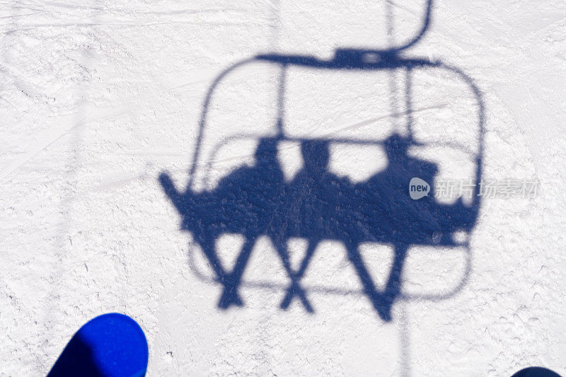缆车上的滑雪者在雪地上的影子