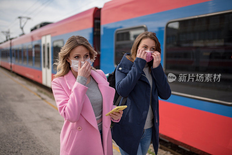 两个戴着防护面罩的妇女经过火车