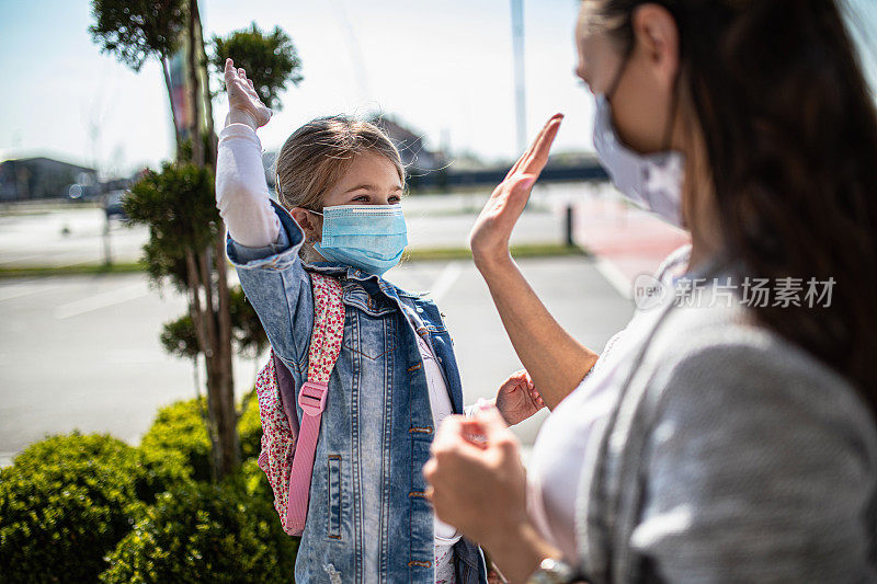 带着女儿戴着防护面具购物的女人