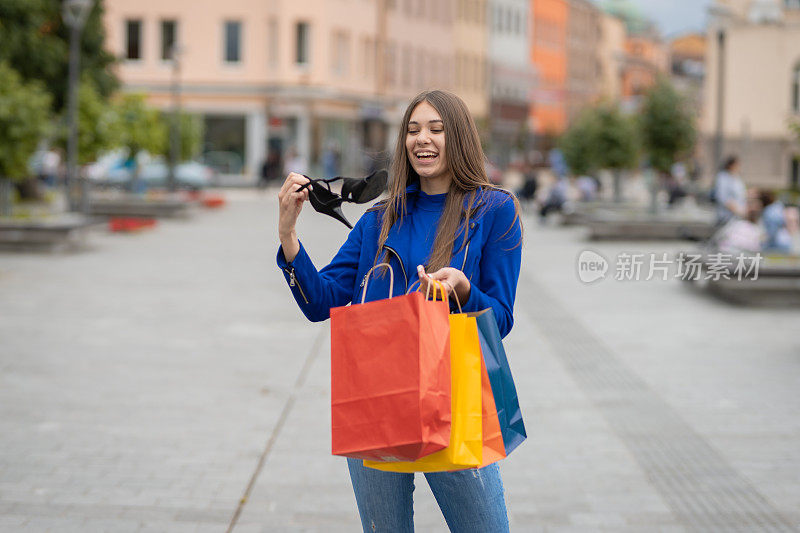 年轻快乐的女人带着购物袋走在街上