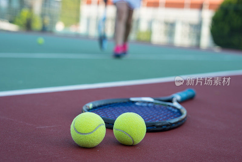 两个网球和球拍在硬地上