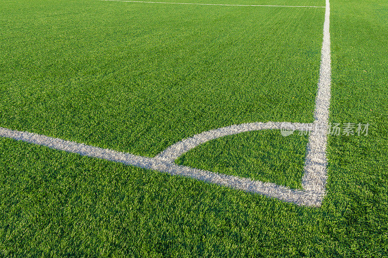 球场上绿草白边线。人造草皮足球场。人造绿草纹理。露天体育场中的人造足球场