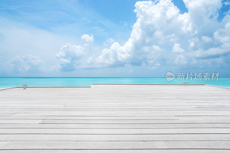 木制码头与蓝绿色的海和云天空的背景