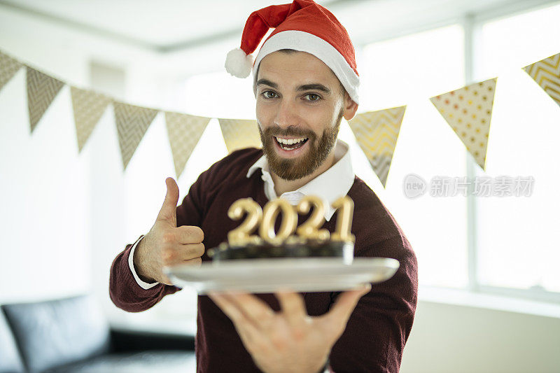 一个男人在新年派对上拿着巧克力蛋糕玩得很开心