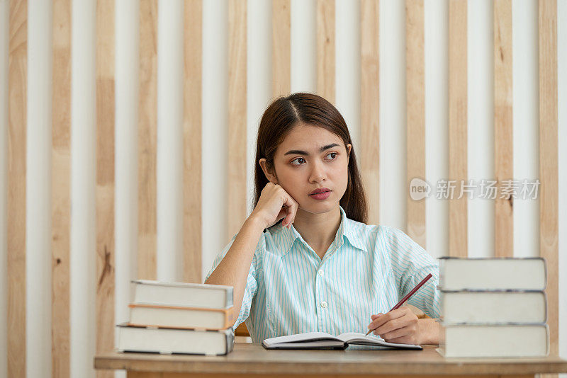 快乐年轻的亚洲商业女性思考梦想有许多想法，而在办公室工作