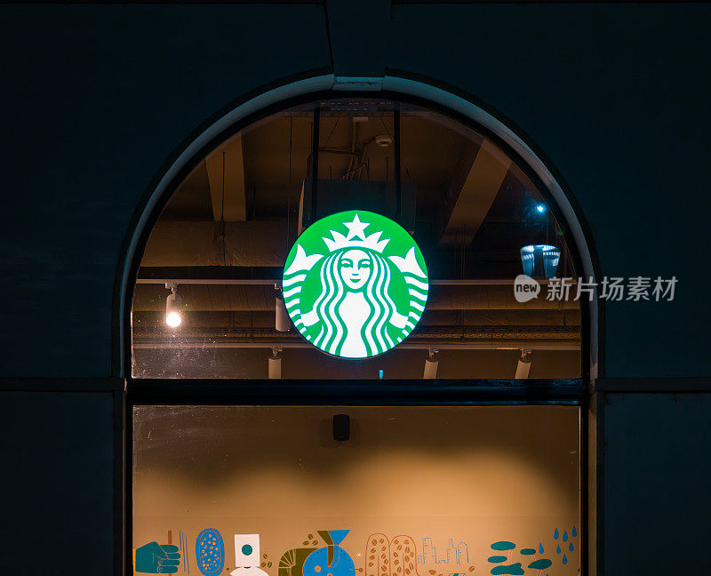 位于布加勒斯特中心的咖啡馆的窗户上照亮了星巴克的标志。
