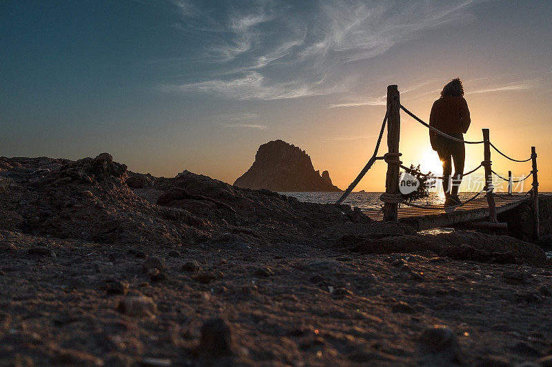 日落时分的埃斯韦德拉岛，一个女孩在散步。卡拉德霍尔特伊比沙岛。