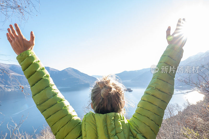 一名徒步旅行的男子举起手臂，凝视着令人惊叹的风景