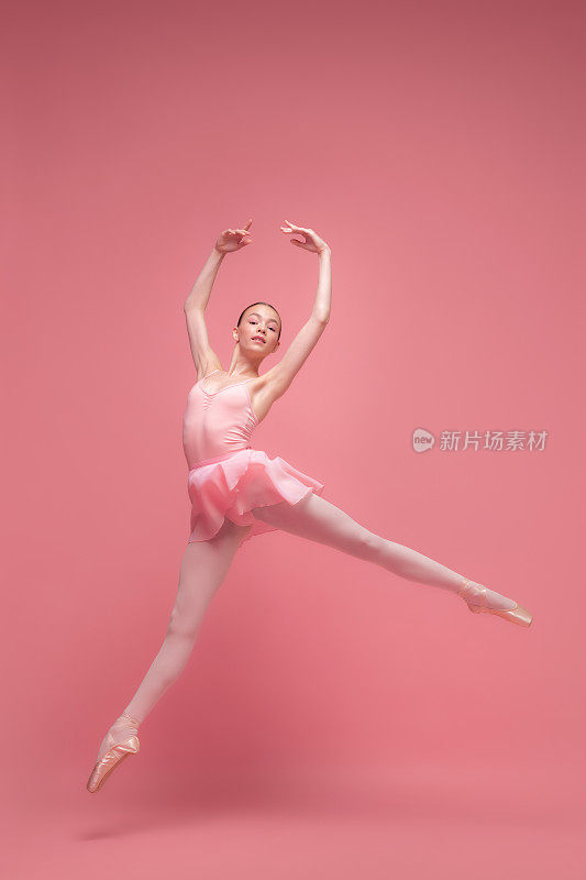 年轻美丽优雅的芭蕾舞者，芭蕾舞者舞蹈孤立在粉红色的工作室背景。艺术，运动，动作，灵活性，灵感概念。