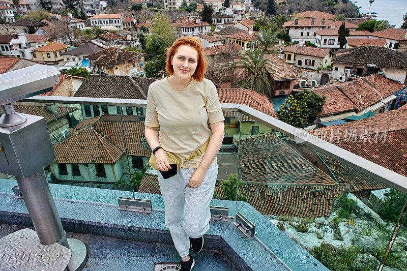 土耳其安塔利亚老城，一位红头发的欧洲妇女在拍照。