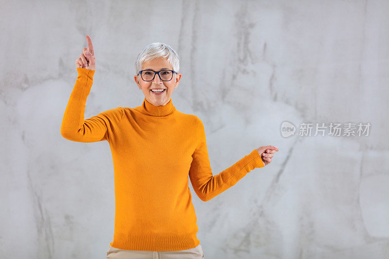 自信美丽成熟的女教师孤立在灰色的背景