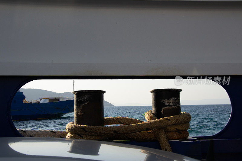 在一艘船上的系缆桩的特写，美丽的平静的水和船在前面