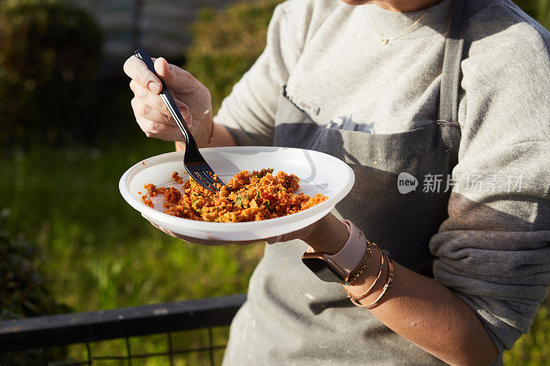 一名年轻女子在午休时间在车间的花园里吃午饭