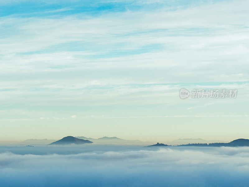 在日出前的薄雾缭绕的早晨，群山突出在云层之上
