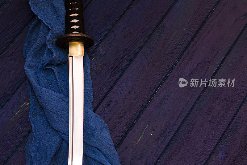 木质背景上的日本武士刀配上蓝色的披肩