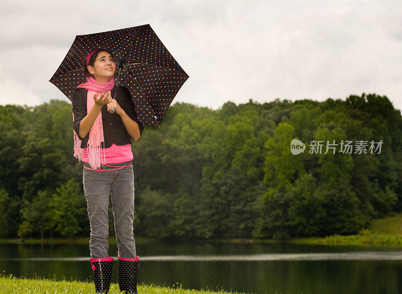 十几岁的女孩拿着伞检查是否下雨