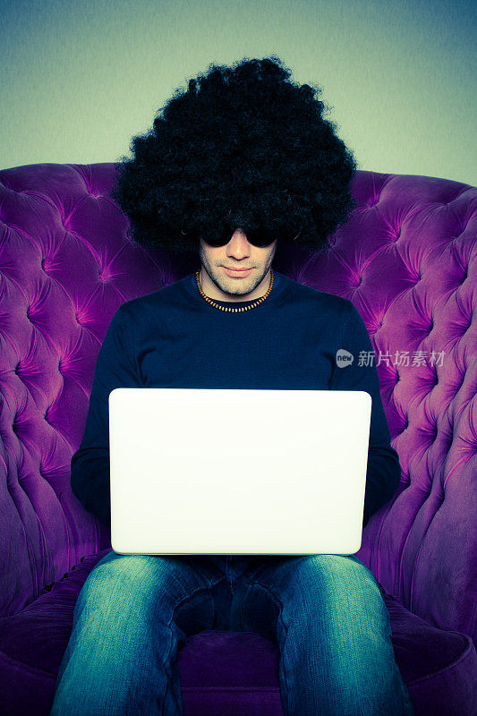 戴着非洲式假发和白色笔记本电脑的男人