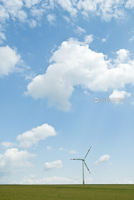 风力涡轮机在麦田下的戏剧性的云彩