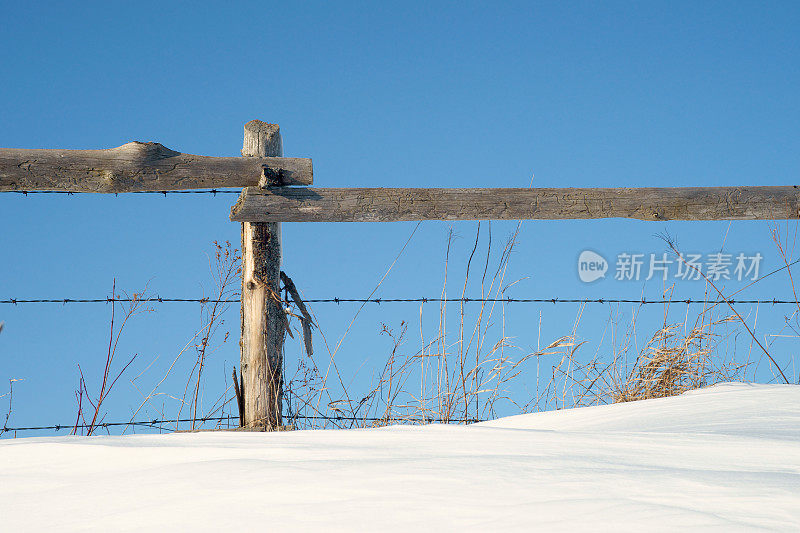 农场栅栏在冬天有雪和天空。